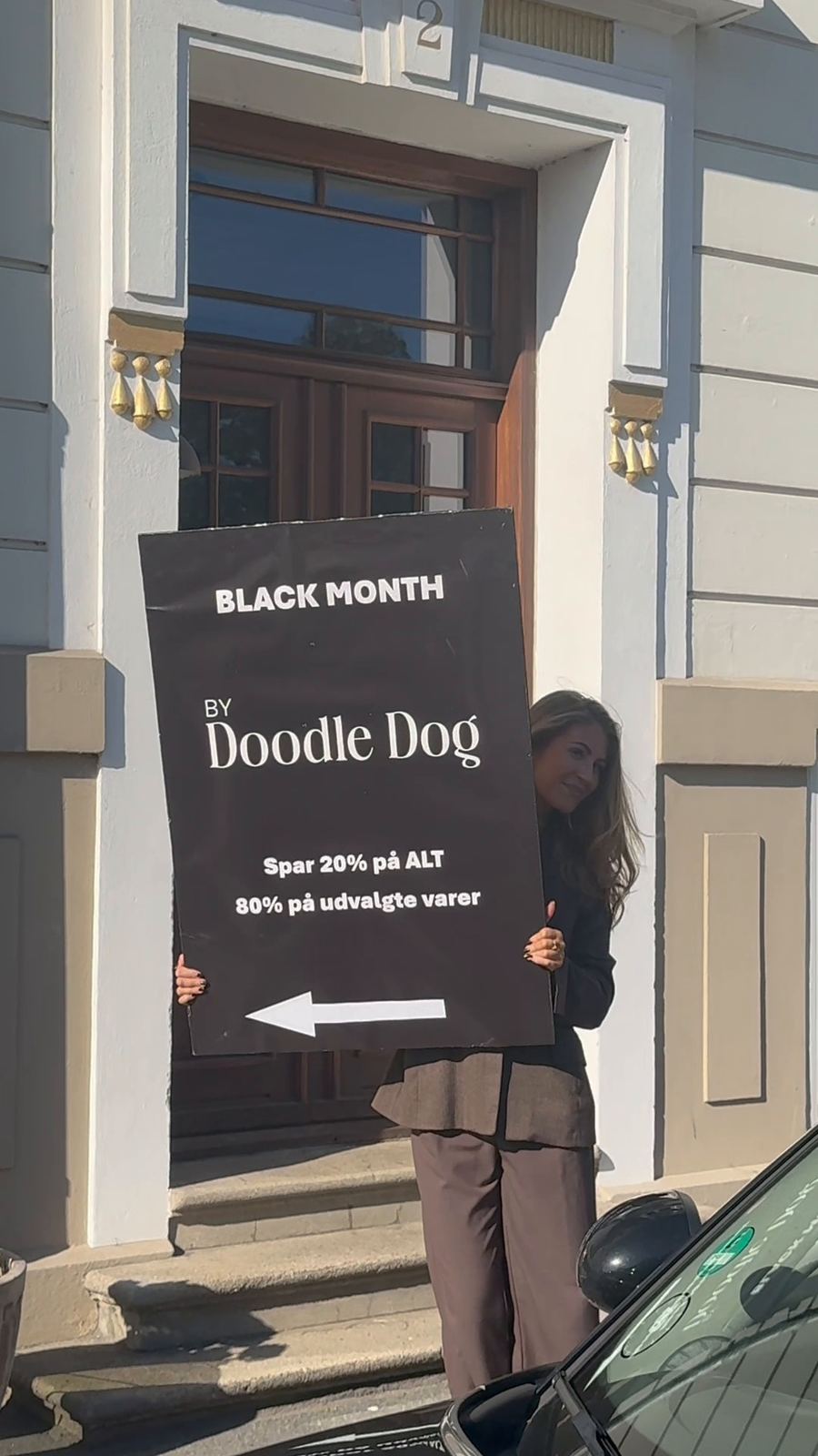 Laura med Black Month-skylten på gatan